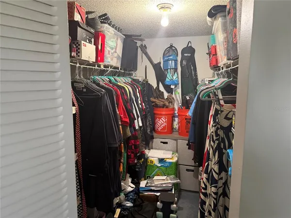 a view of walk in closet with clothes