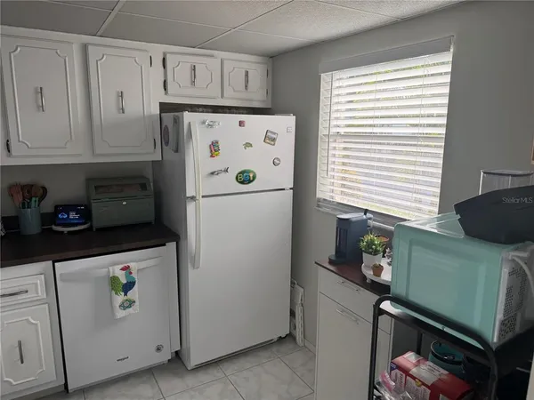 a kitchen with refrigerator and cabinets