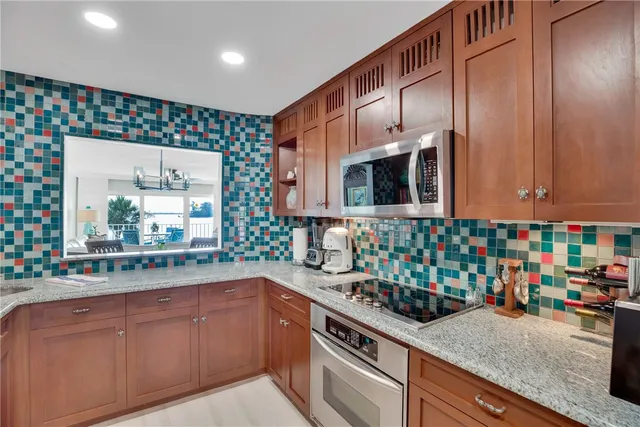 a kitchen with kitchen island granite countertop a sink and cabinets