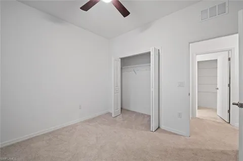 an empty room with chandelier fan