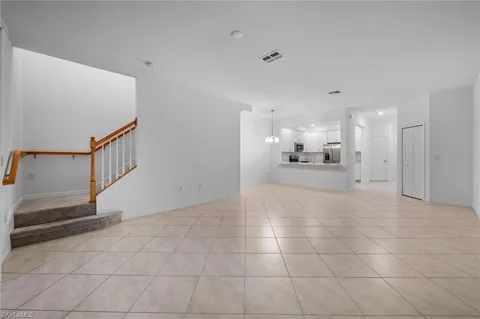 a view of a livingroom with kitchen and staircase