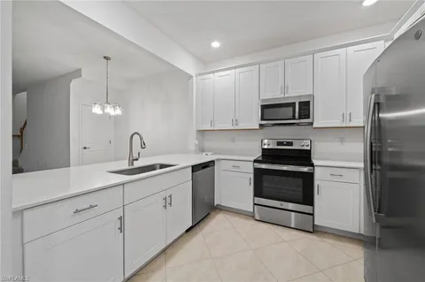 a kitchen with appliances a sink and cabinets