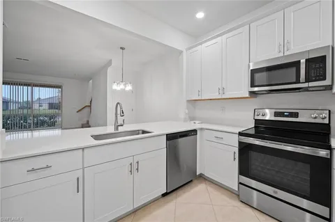 a kitchen with white cabinets and appliances