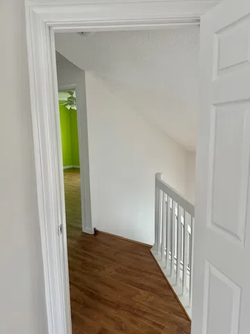 a view of a hallway with wooden floor and entryway