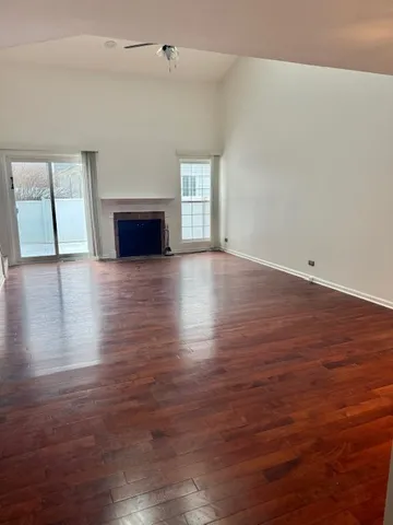 an empty room with wooden floor and fireplace