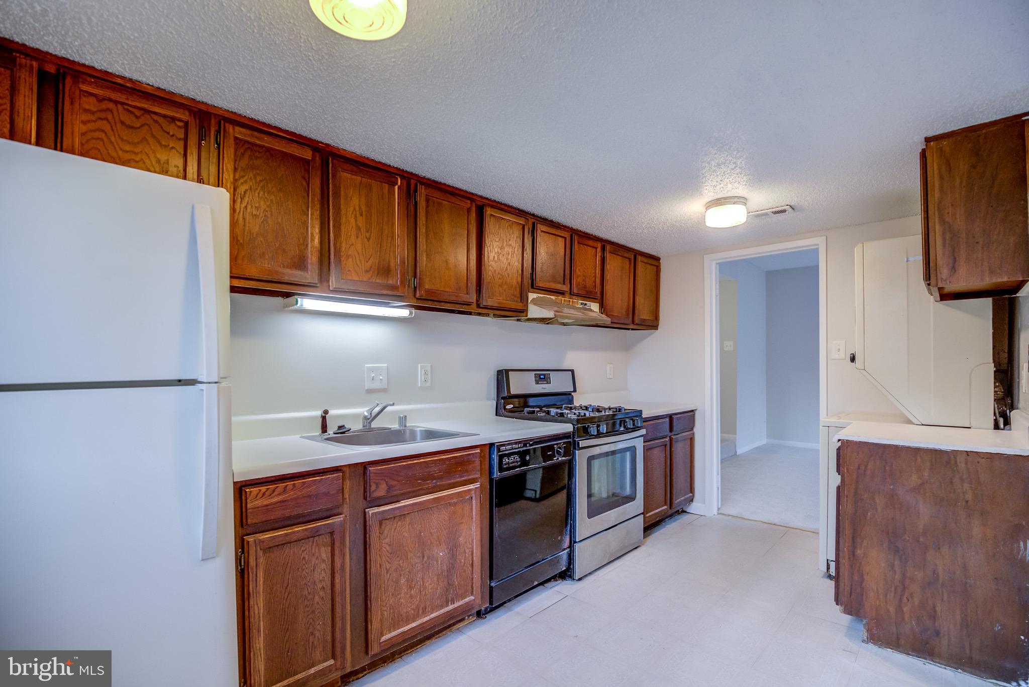 11813 Breton Court, Unit 2B Reston, VA 20191 - Photo 6 of 17 a kitchen with stainless steel appliances granite countertop a stove a sink and a refrigerator