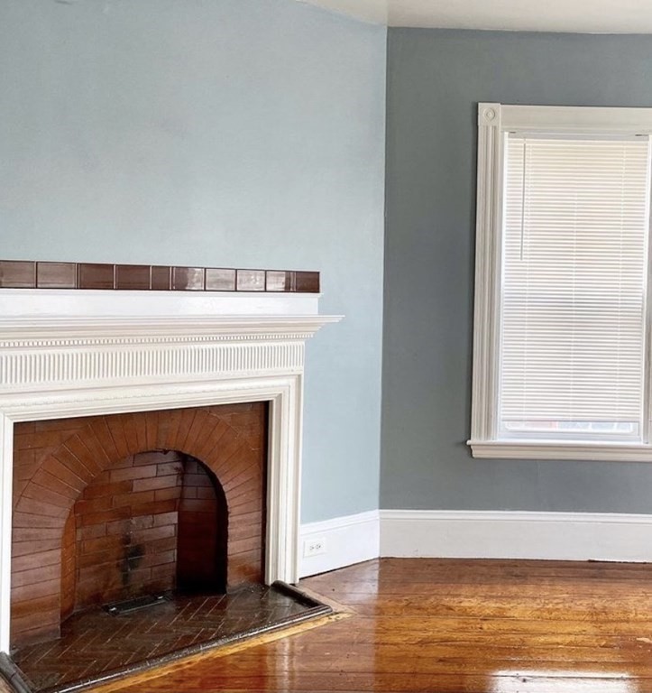 52 Harvest Street, Unit 1 Boston, MA 02125 - Photo 26 of 35 a living room with a fireplace and a wooden floor