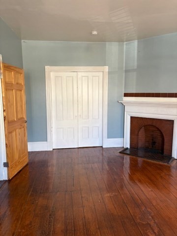 52 Harvest Street, Unit 1 Boston, MA 02125 - Photo 30 of 35 a view of an empty room with wooden floor fireplace and a window