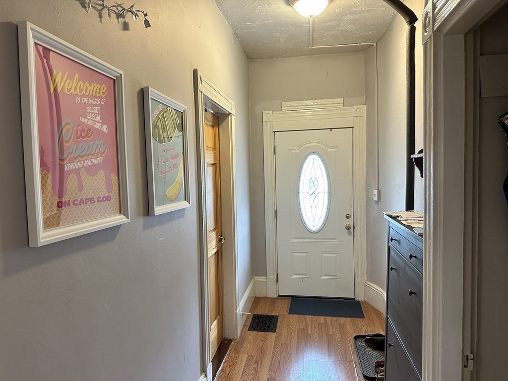 52 Harvest Street, Unit 1 Boston, MA 02125 - Photo 3 of 35 a view of a hallway with wooden floor cabinet and a mirror