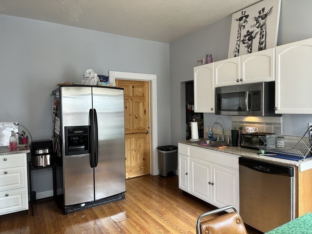 52 Harvest Street, Unit 1 Boston, MA 02125 - Photo 5 of 35 a kitchen with stainless steel appliances a refrigerator a stove top oven a sink and dishwasher