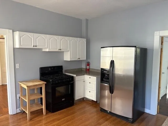 a kitchen with stainless steel appliances granite countertop a stove a refrigerator and a wooden cabinets