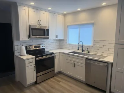 a kitchen with stainless steel appliances granite countertop a sink a stove a microwave and cabinets