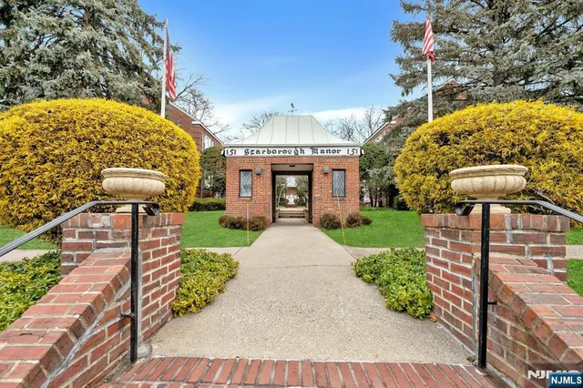 a front view of a house with a yard and potted plants