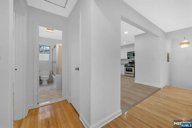a view of a hallway with wooden floor and closet
