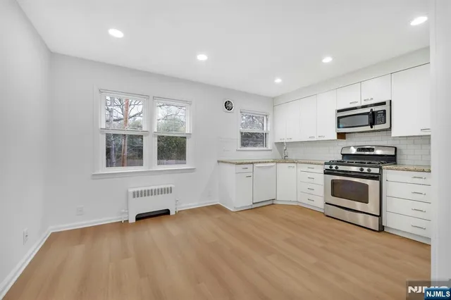 a kitchen with stainless steel appliances kitchen island wooden cabinets and a stove top oven