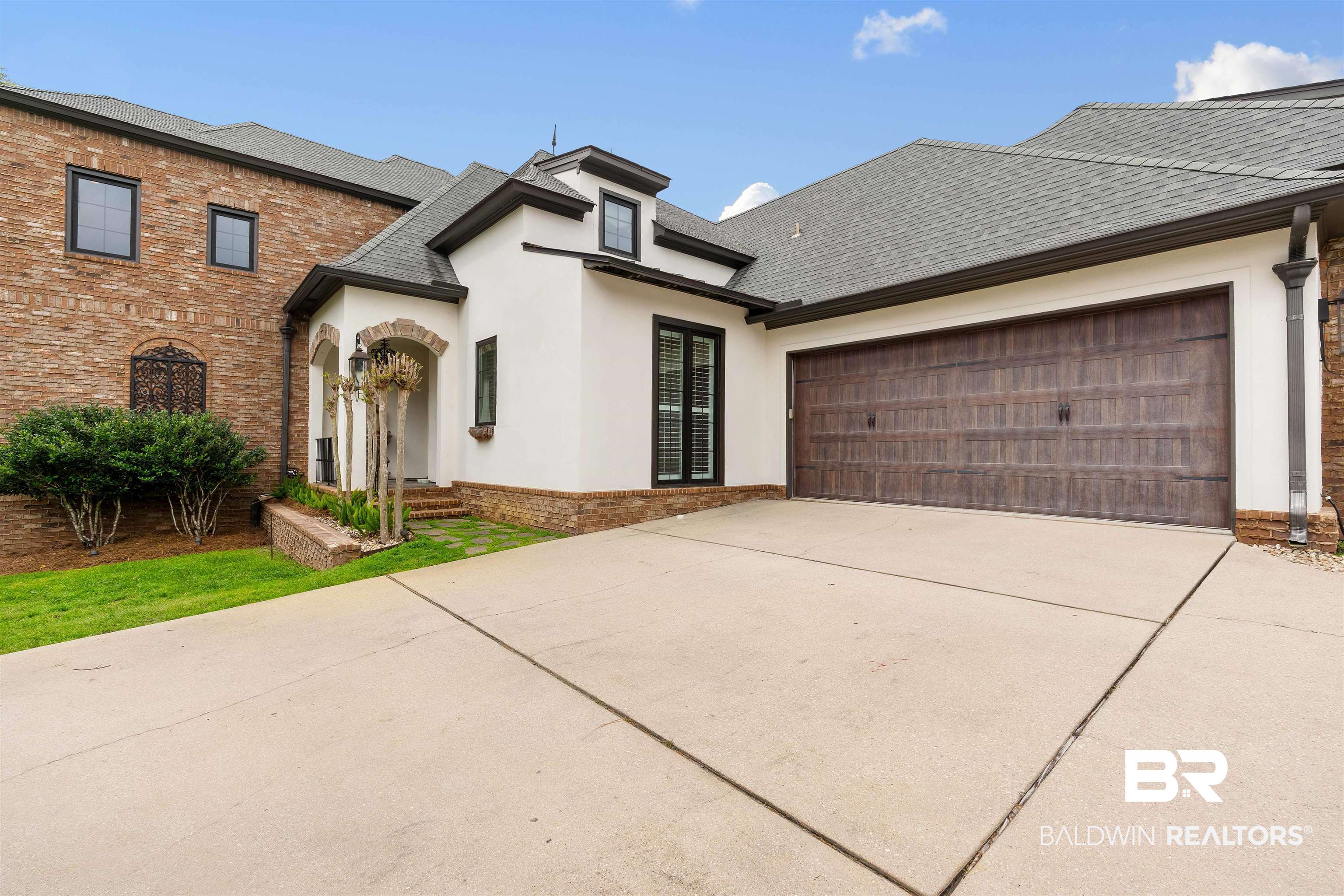 3584 Rue Royal Mobile, AL 36693 - Photo 2 of 35 View of front facade with an attached garage, stucco siding, a shingled roof, concrete driveway, and brick siding