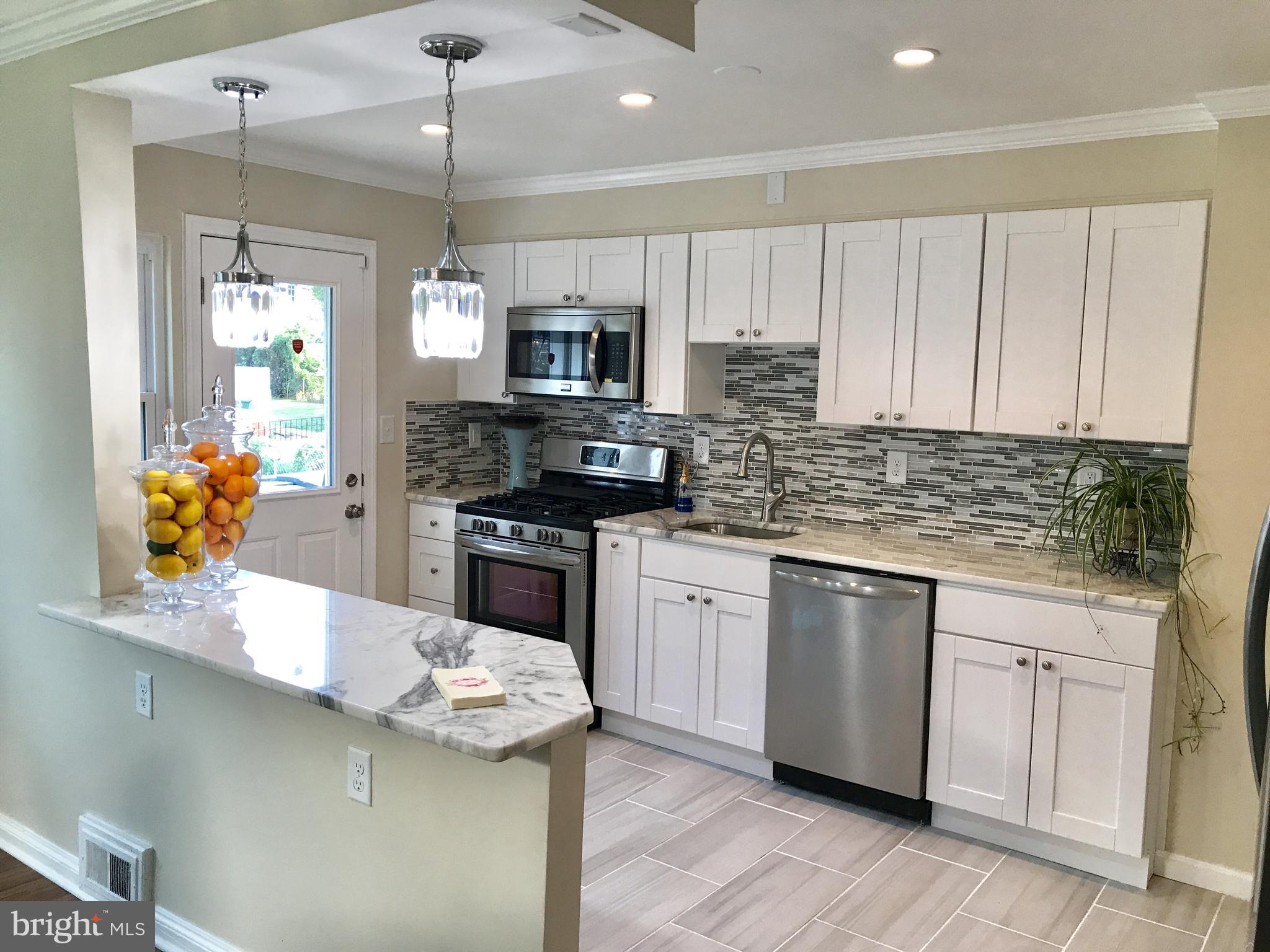 1713 Heathfield Road Baltimore, MD 21239 - Photo 1 of 26 a kitchen with stainless steel appliances kitchen island granite countertop a sink a stove and cabinets