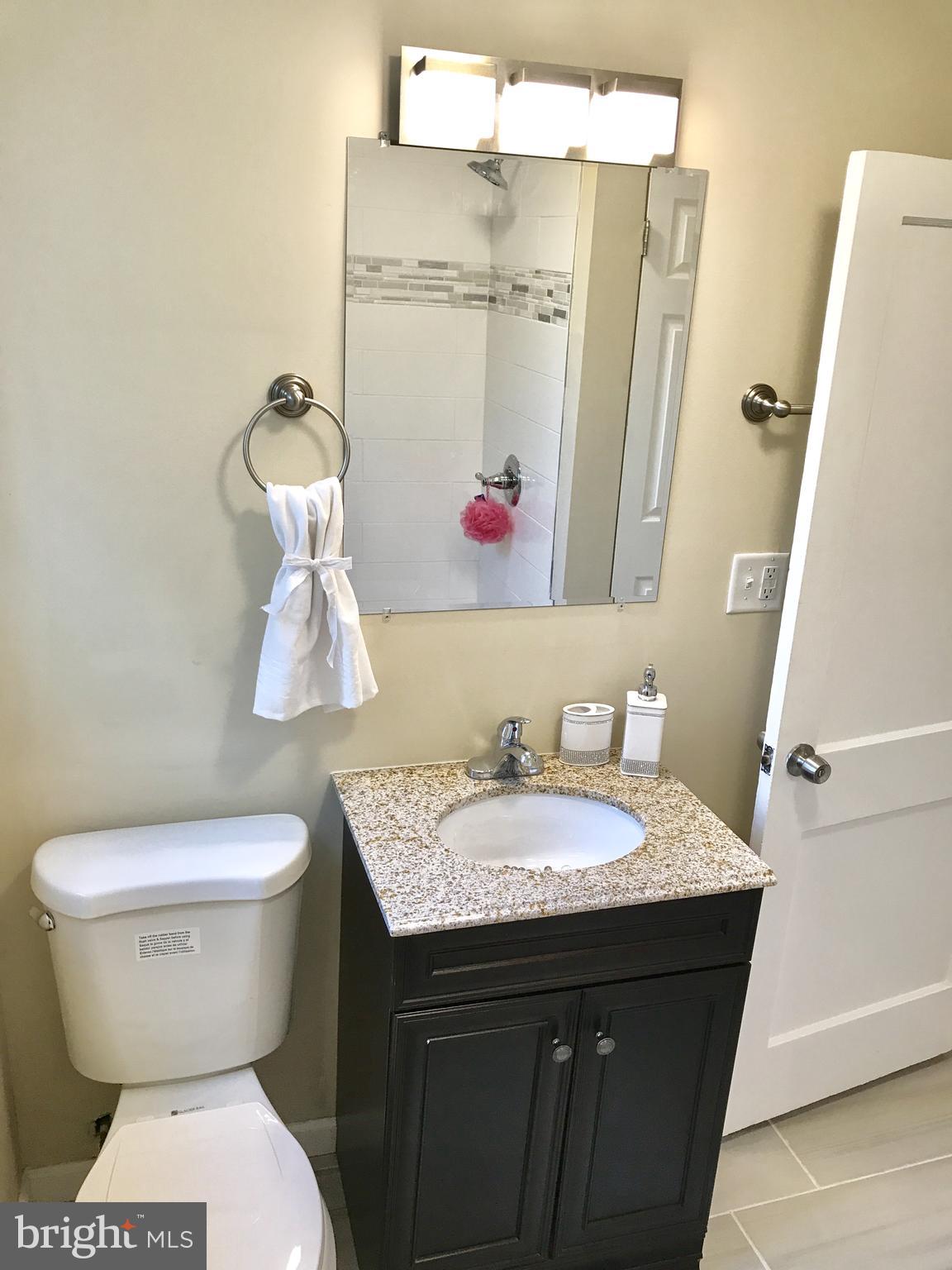 1713 Heathfield Road Baltimore, MD 21239 - Photo 17 of 26 a bathroom with a granite countertop toilet sink and mirror