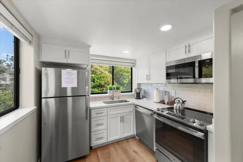 a kitchen with stainless steel appliances a stove sink microwave and cabinets