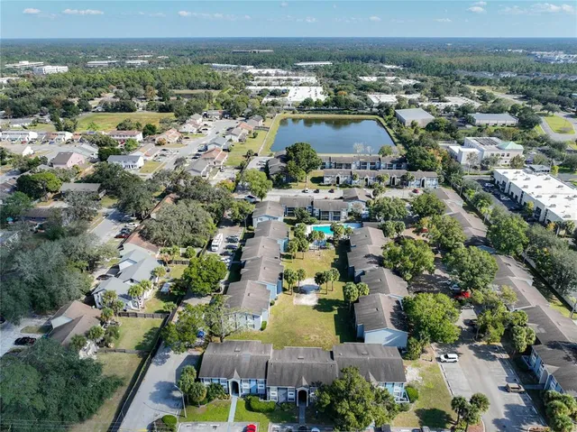 front view of a house with a yard and palm trees