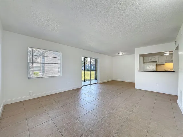 an empty room with windows and fireplace