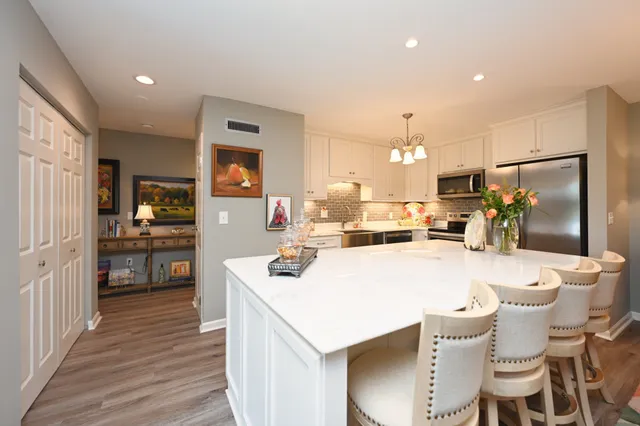 a dining room with wooden floor a chandelier a wooden table and chairs