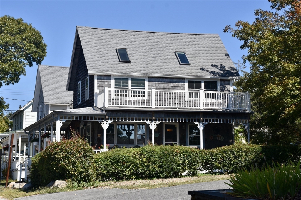 a front view of a house with plants and trees