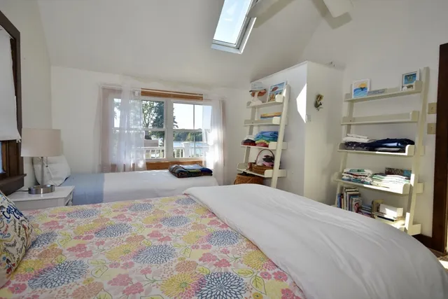 a bedroom with a bed a large window with the outer view