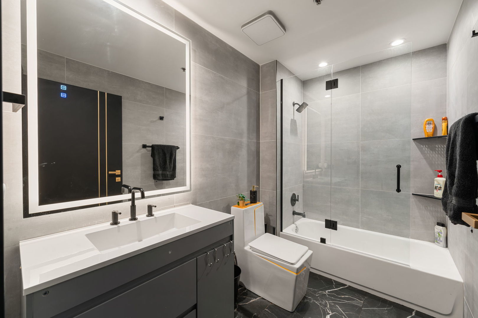 1305 South Michigan Avenue, Unit 907 Chicago, IL 60605 - Photo 18 of 20 a bathroom with a tub a sink a toilet and a large mirror