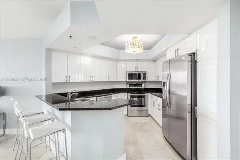 a kitchen with stainless steel appliances granite countertop a refrigerator a stove and a sink