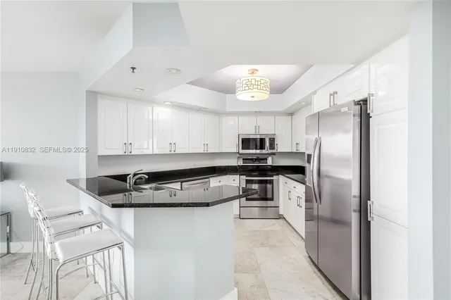 a kitchen with stainless steel appliances granite countertop a refrigerator a stove and a sink