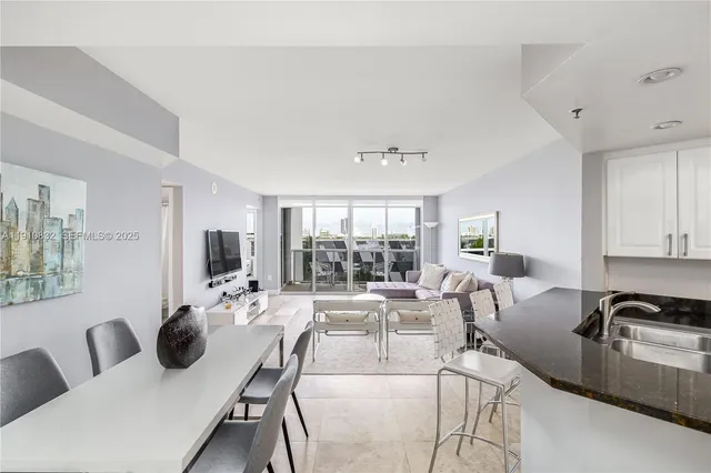 a living room with furniture kitchen view and large windows