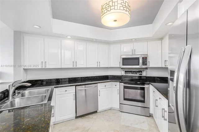 a kitchen with cabinets stainless steel appliances and a sink
