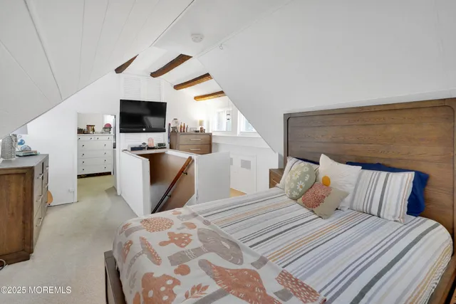 a bedroom with a bed a television and a large window