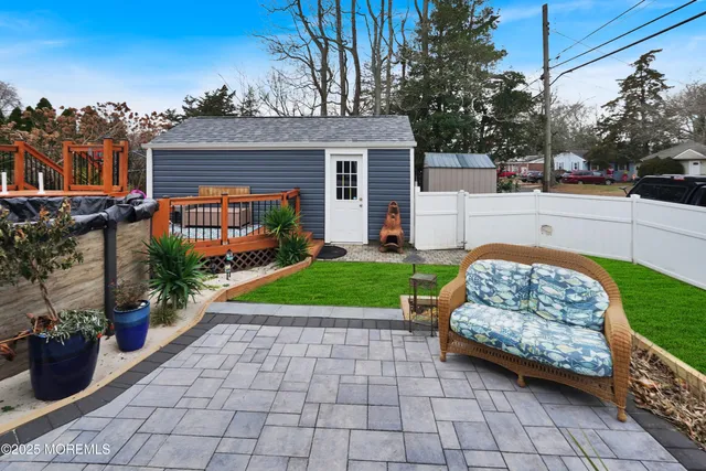 a view of a house with a small yard and a patio