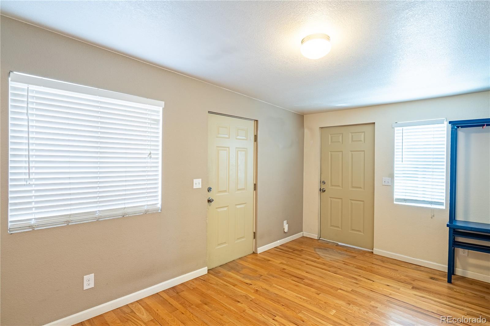 1124 Newark Street Aurora, CO 80010 - Photo 13 of 32 a view of an empty room with wooden floor and a window