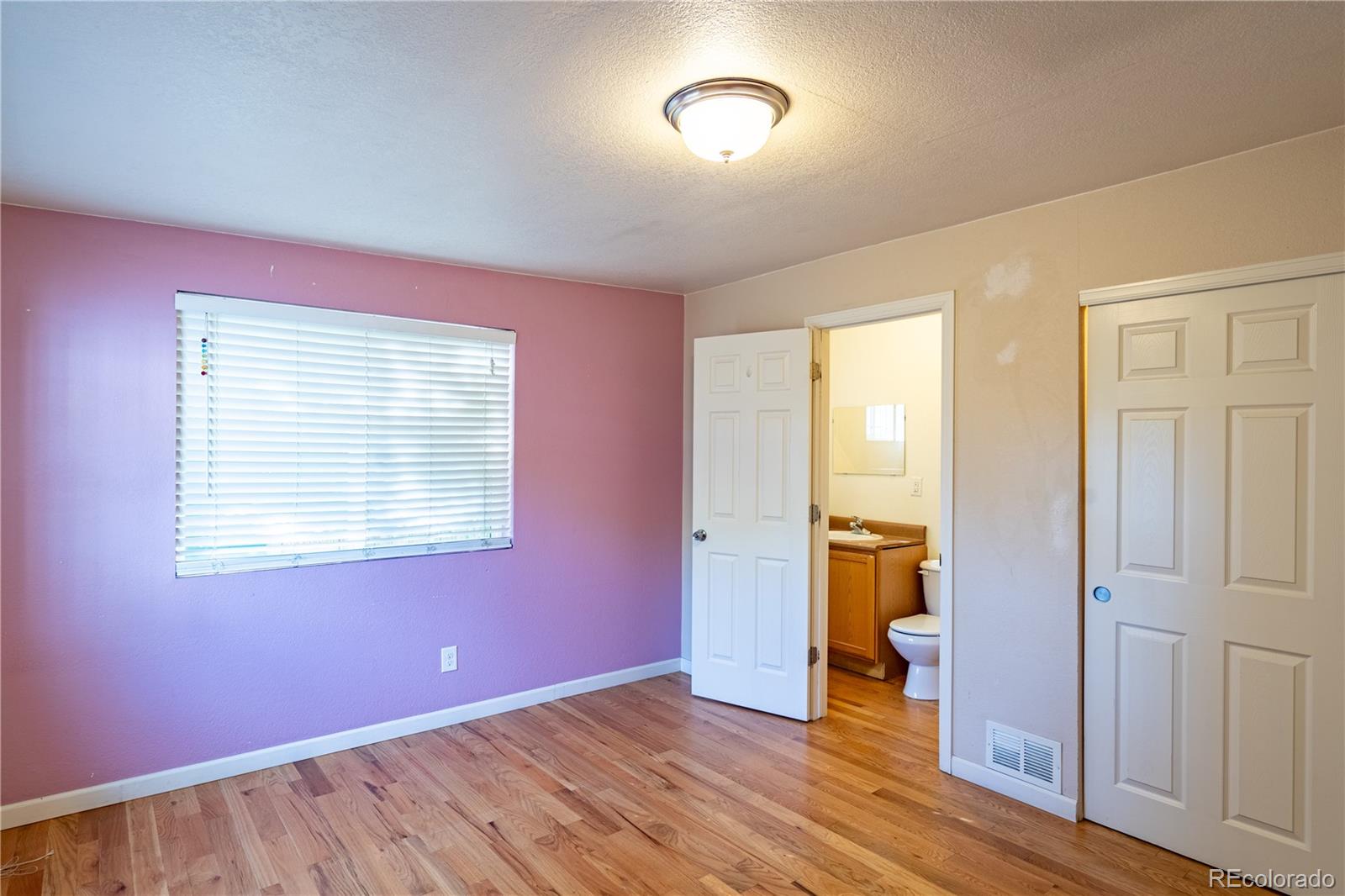 1124 Newark Street Aurora, CO 80010 - Photo 14 of 32 an empty room with wooden floor and windows