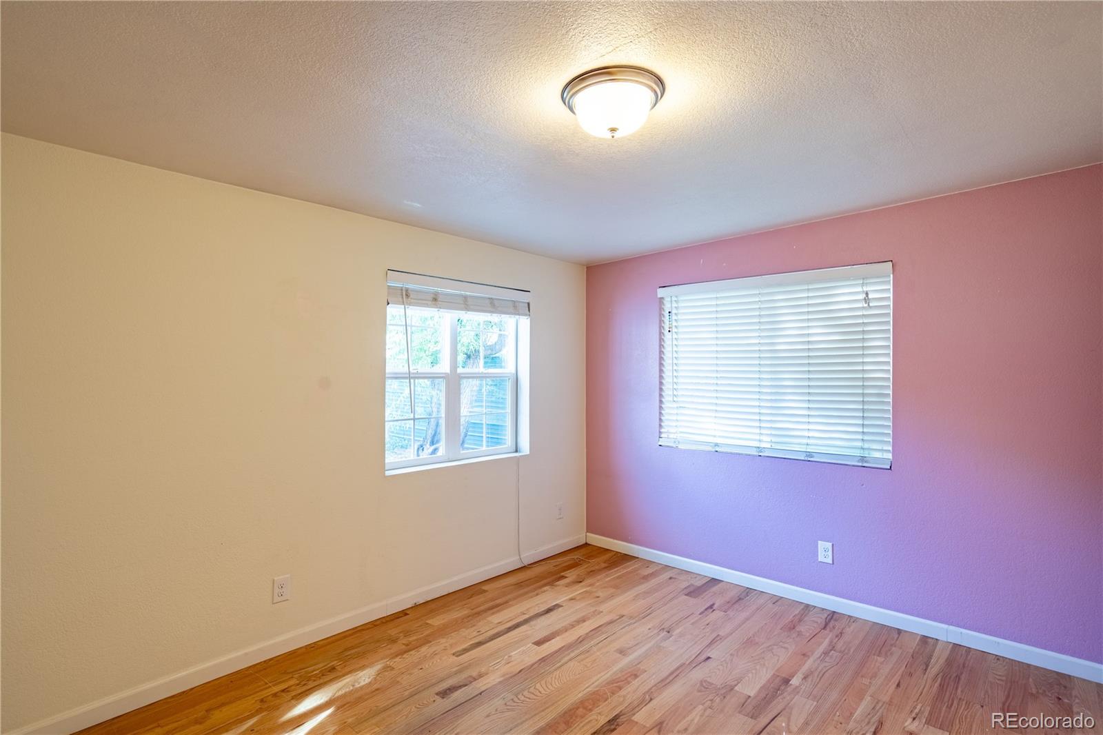 1124 Newark Street Aurora, CO 80010 - Photo 15 of 32 a view of an empty room with wooden floor and a window