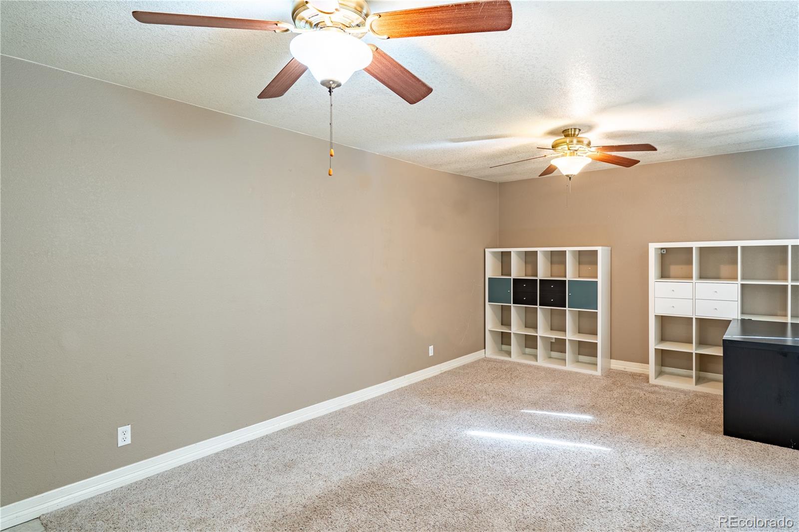 1124 Newark Street Aurora, CO 80010 - Photo 19 of 32 an empty room with windows and fan