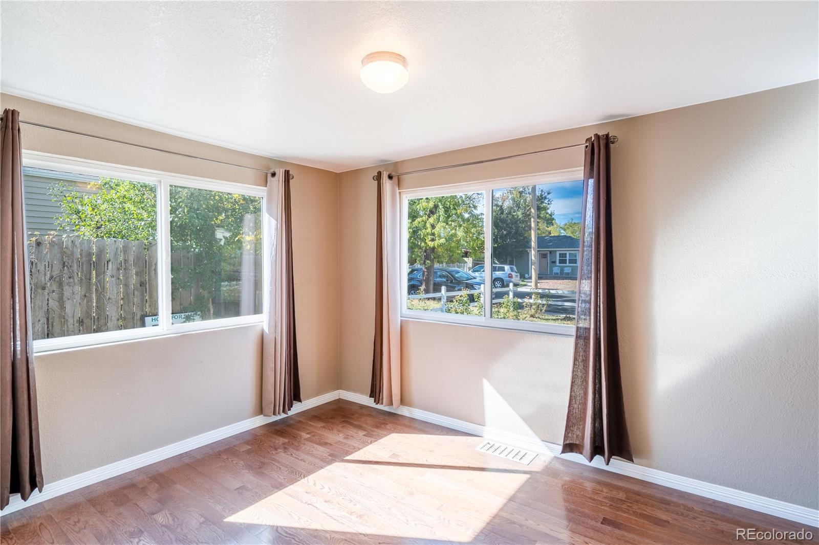 1124 Newark Street Aurora, CO 80010 - Photo 9 of 32 an empty room with wooden floor and a window