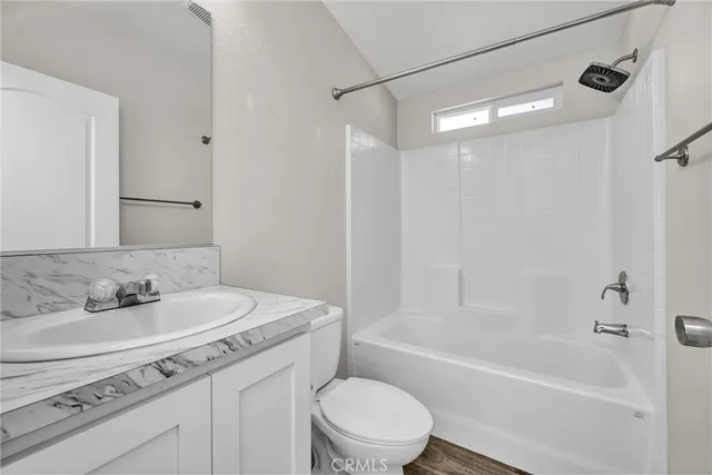 a bathroom with a sink toilet vanity and shower