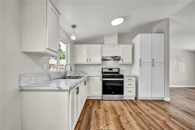 a kitchen with kitchen island granite countertop a stove a sink and a refrigerator