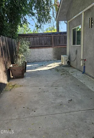 a view of backyard and wooden fence