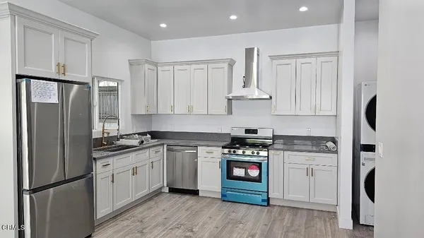a kitchen with stainless steel appliances granite countertop a stove a refrigerator and a sink