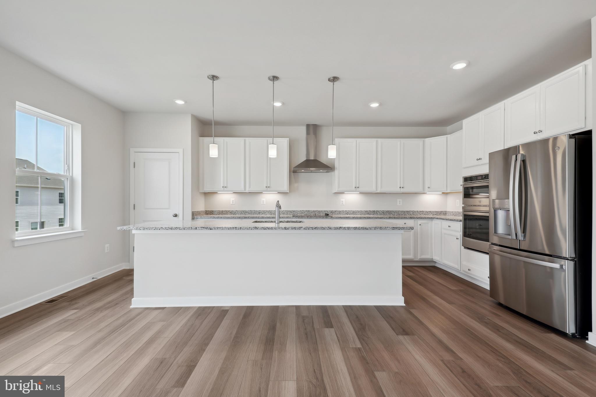 430 Silver Birch Drive, Unit ASHTON 241 Ranson, WV 25438 - Photo 5 of 23 a kitchen with kitchen island wooden floors appliances and cabinets