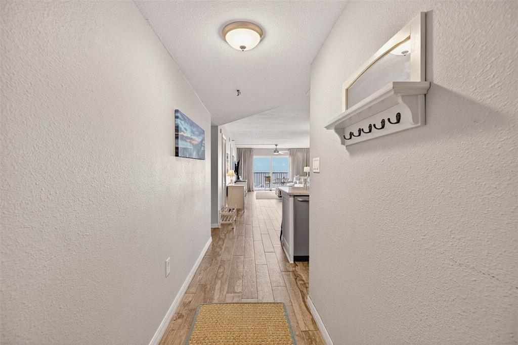 14300 Gulf Boulevard, Unit 104 Madeira Beach, FL 33708 - Photo 11 of 42 a view of a hallway with a white kitchen