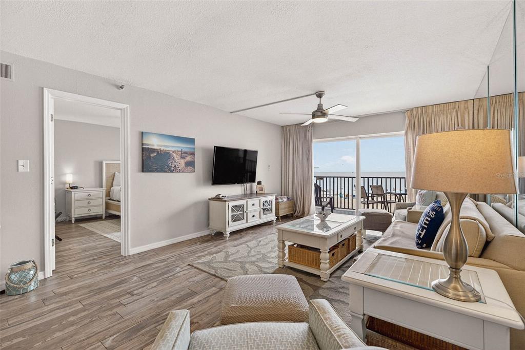 14300 Gulf Boulevard, Unit 104 Madeira Beach, FL 33708 - Photo 16 of 42 a living room with furniture and a flat screen tv