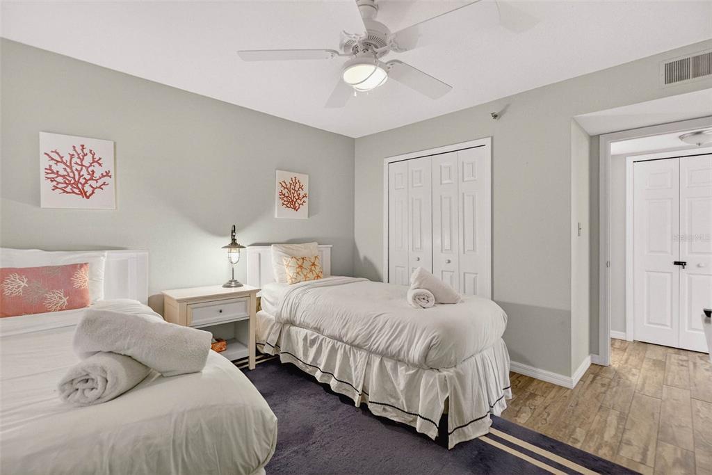 14300 Gulf Boulevard, Unit 104 Madeira Beach, FL 33708 - Photo 19 of 42 a bedroom with two beds and a chandelier