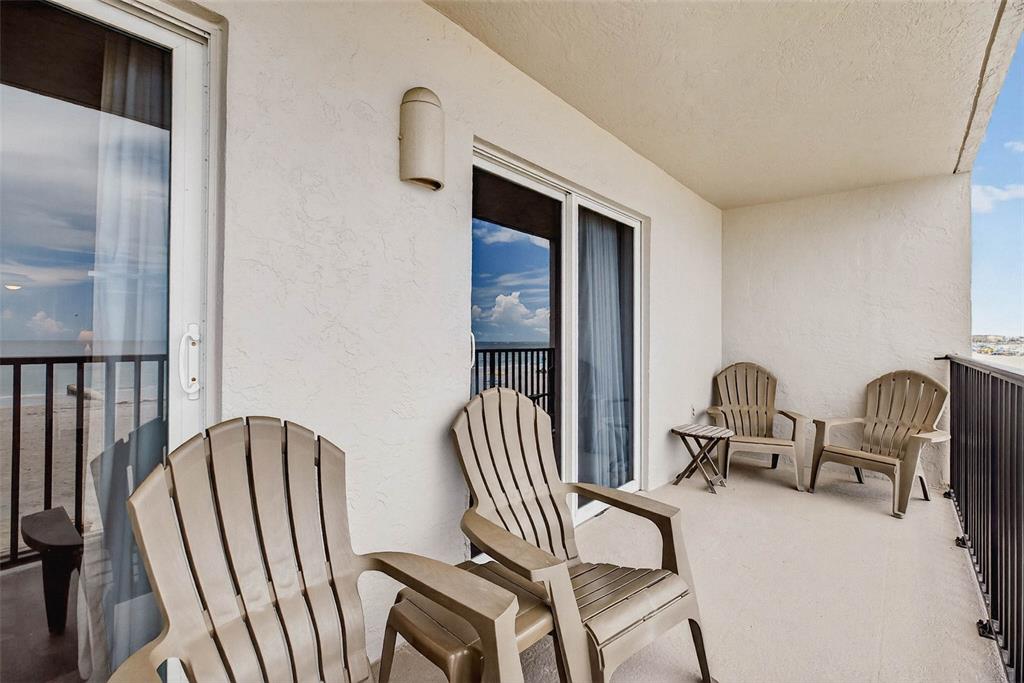 14300 Gulf Boulevard, Unit 104 Madeira Beach, FL 33708 - Photo 29 of 42 a balcony with two chairs and a large window