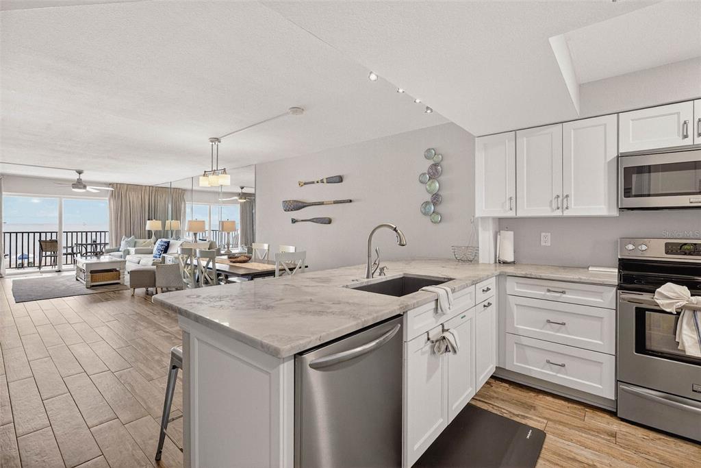 14300 Gulf Boulevard, Unit 104 Madeira Beach, FL 33708 - Photo 6 of 42 a kitchen with white cabinets and appliances